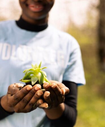 african-american-teenager-advocating-ecology-by-holding-small-plant_482257-91217